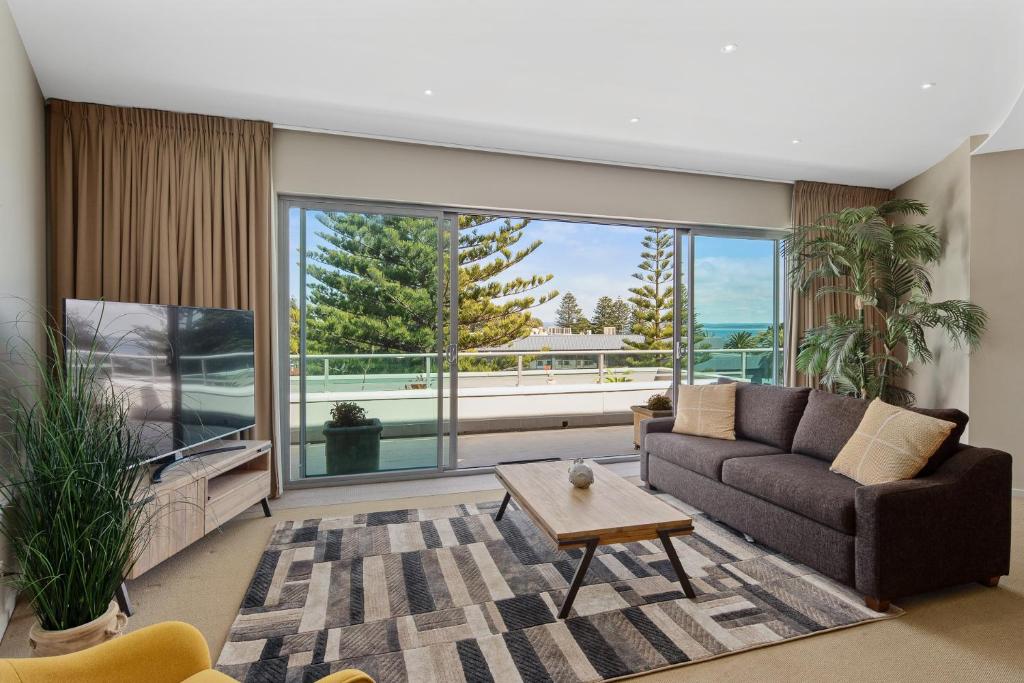a living room with a couch and a large window at Ocean View Penthouse in Cowes