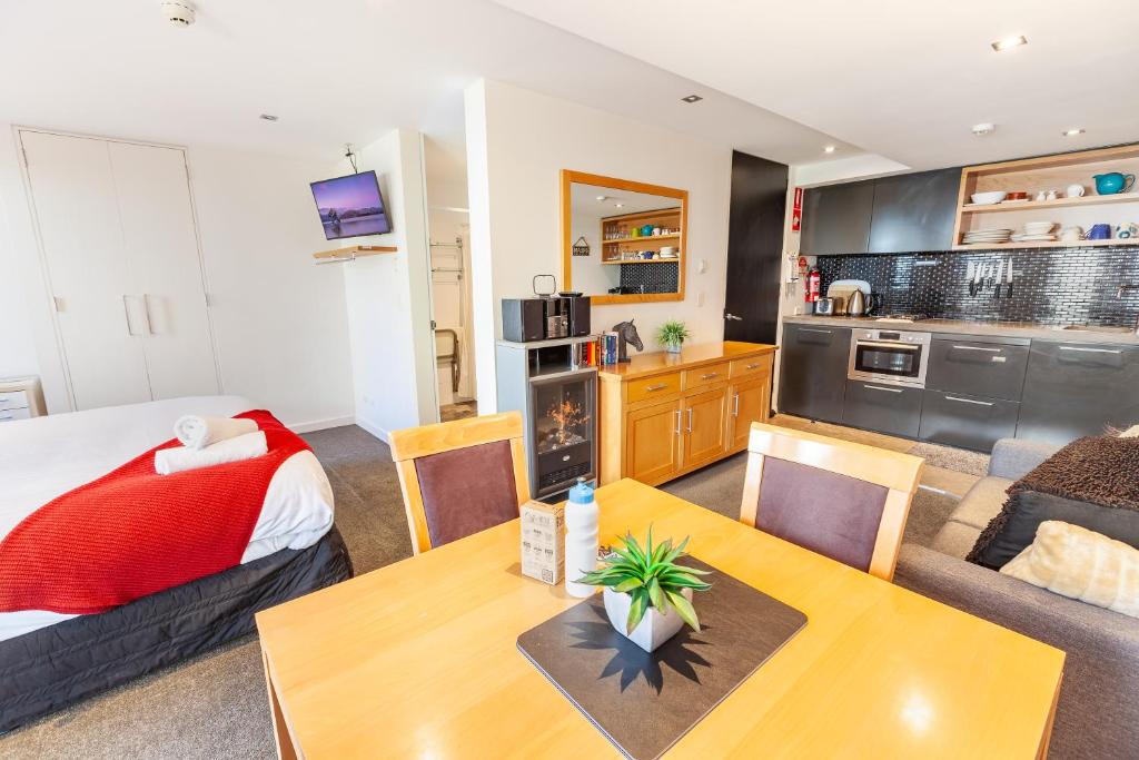 a living room and kitchen with a bed and a table at Powder 2A in Thredbo