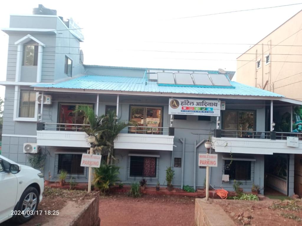 a white car parked in front of a building at Hotel Adinath in Mahabaleshwar