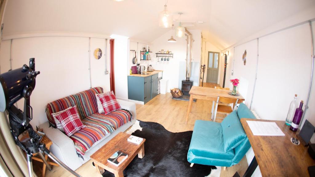 a living room with a couch and a table at Old School Byre in Stoer