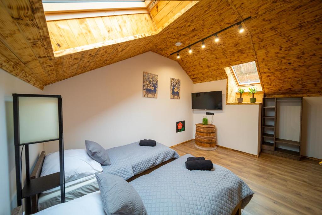 twee bedden in een kamer met een plafond bij Apartamenty Czarni Górale in Barcice