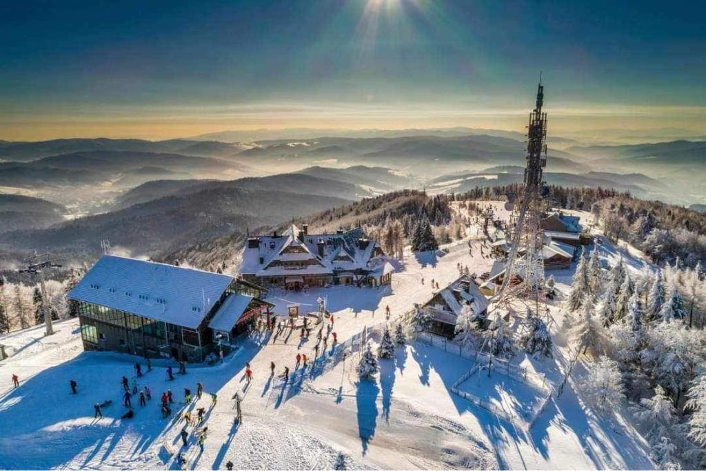 a ski lodge on top of a snow covered mountain at Krynicka Koliba na Jaworzynie Krynickiej in Krynica Zdrój