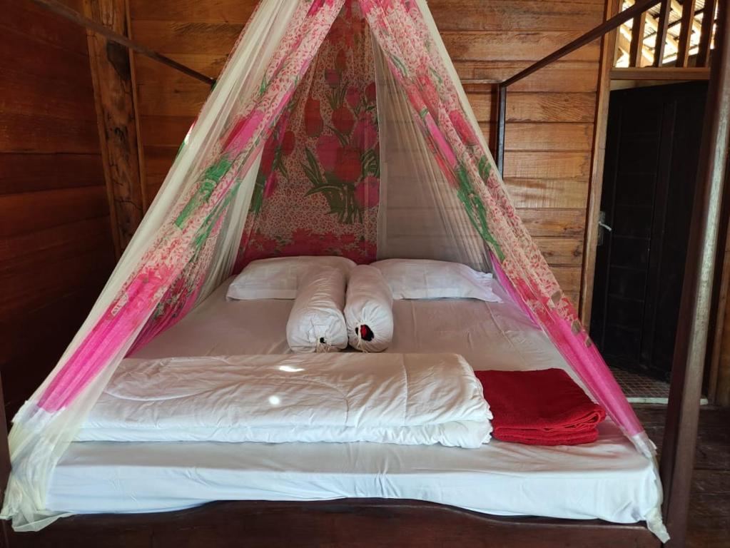 Cama en habitación con mosquitera en Famangkor Homestay, en Yennanas Besir