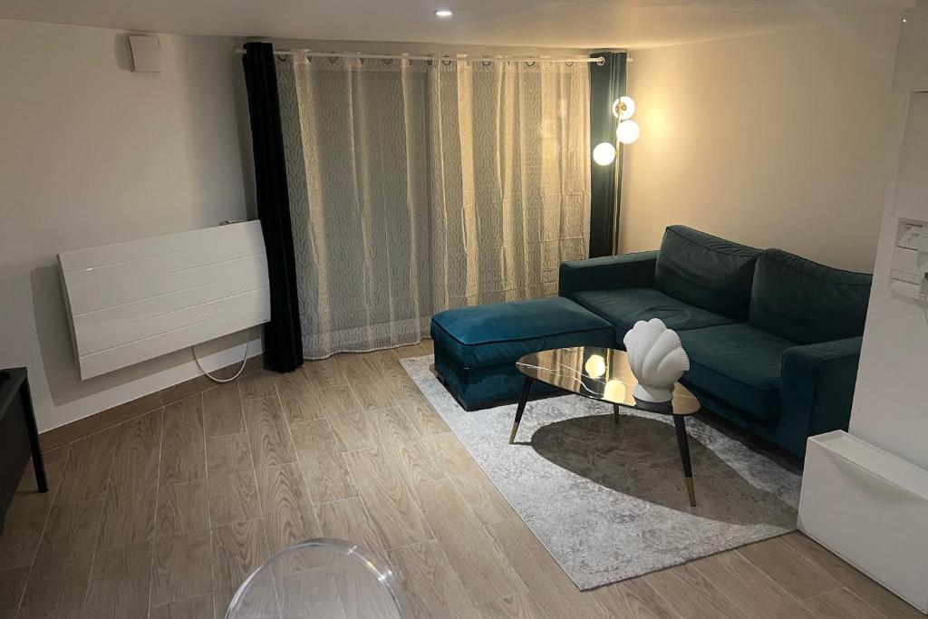 uma sala de estar com um sofá azul e uma mesa em Livry09 Villa Dengous - Cozy Aéroport CDG Wifi 4 pers em Livry-Gargan