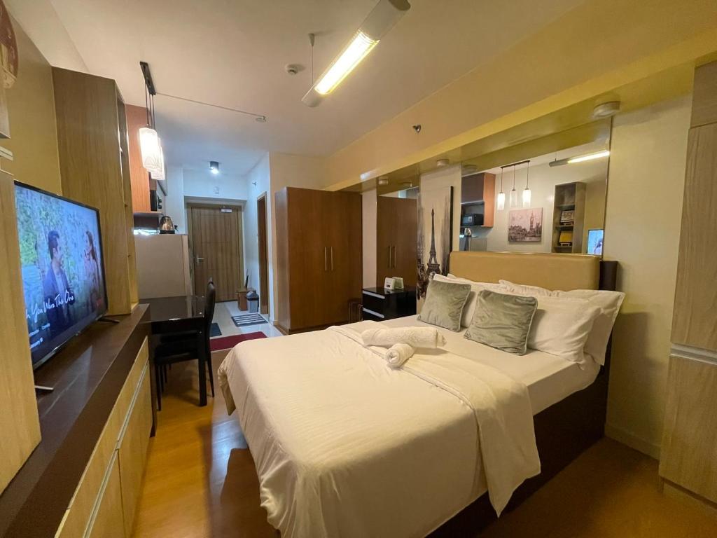 um quarto com uma cama grande e uma televisão em 8 Adriatico em Manilla