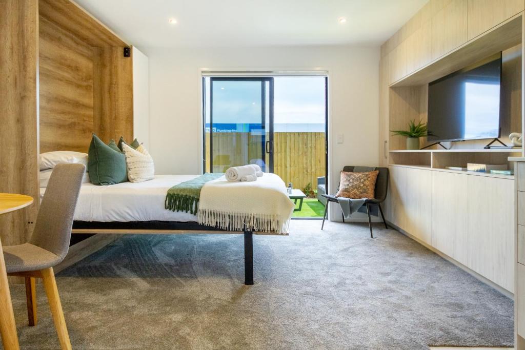 Un dormitorio con una cama grande y una cocina. en Urban Escape Ground Floor Studio, Wilmer St, en Christchurch