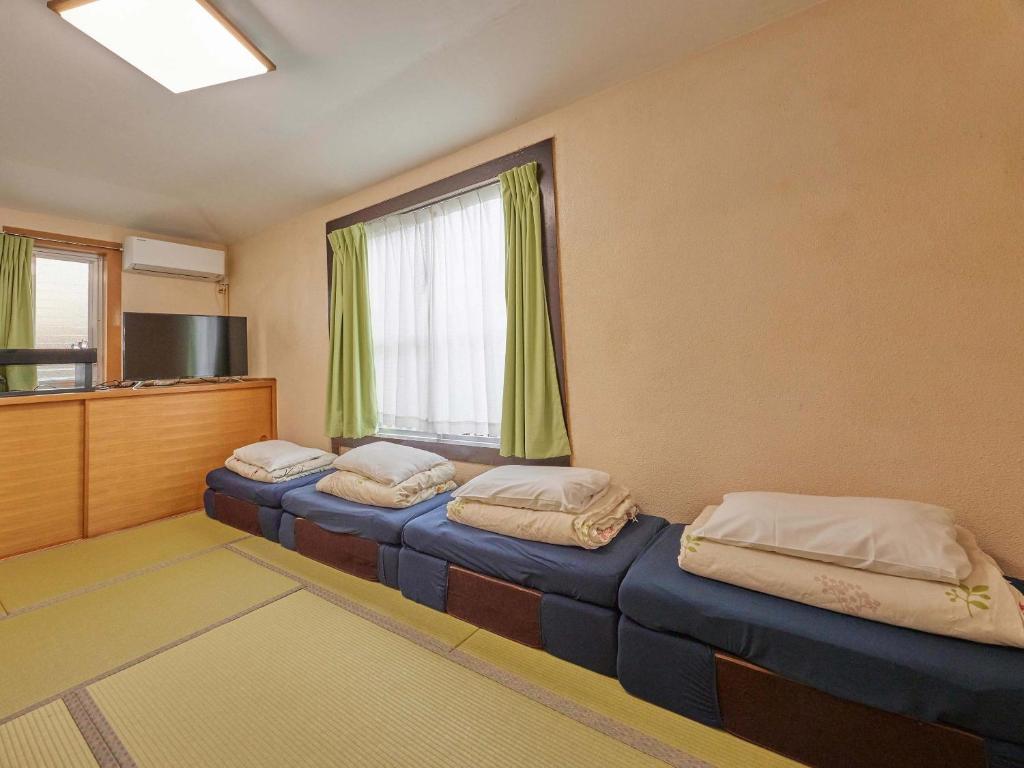 two beds in a room with a window at Yukurina Resort Okinawa in Motobu