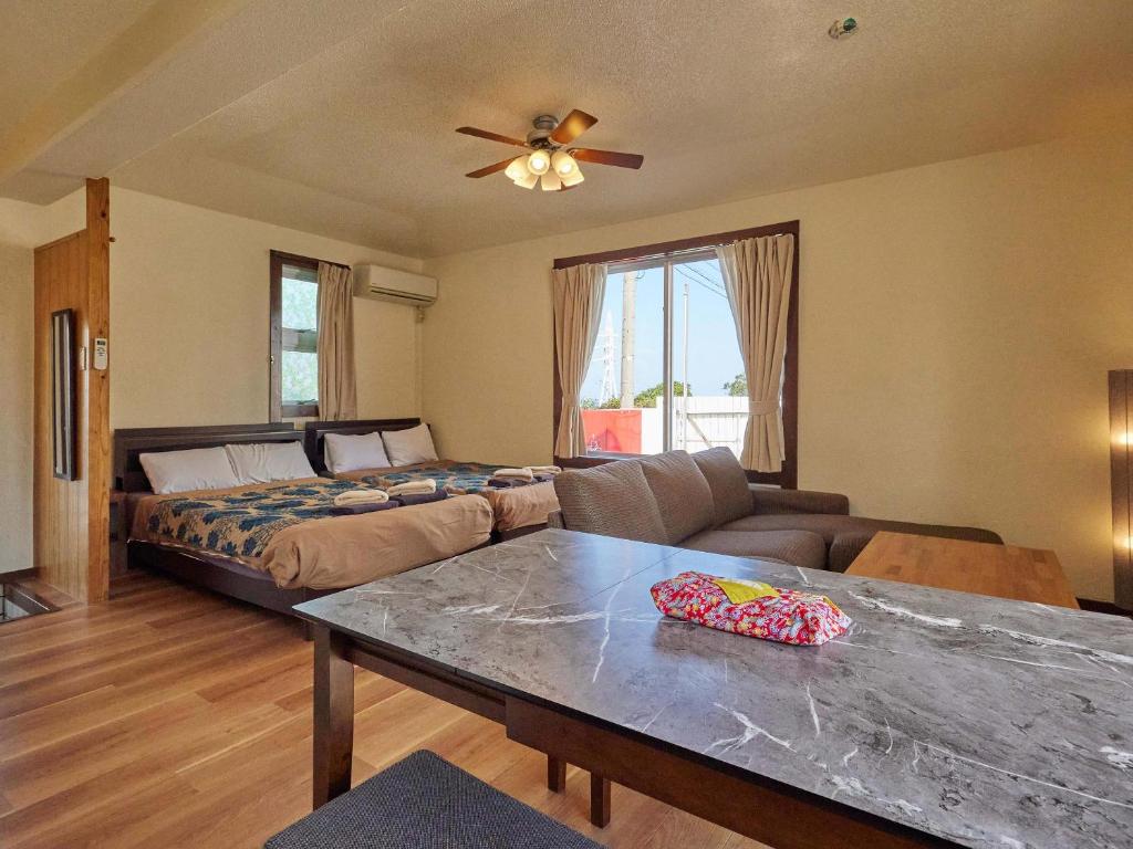 a living room with a bed and a table at Yukurina Resort Okinawa in Motobu