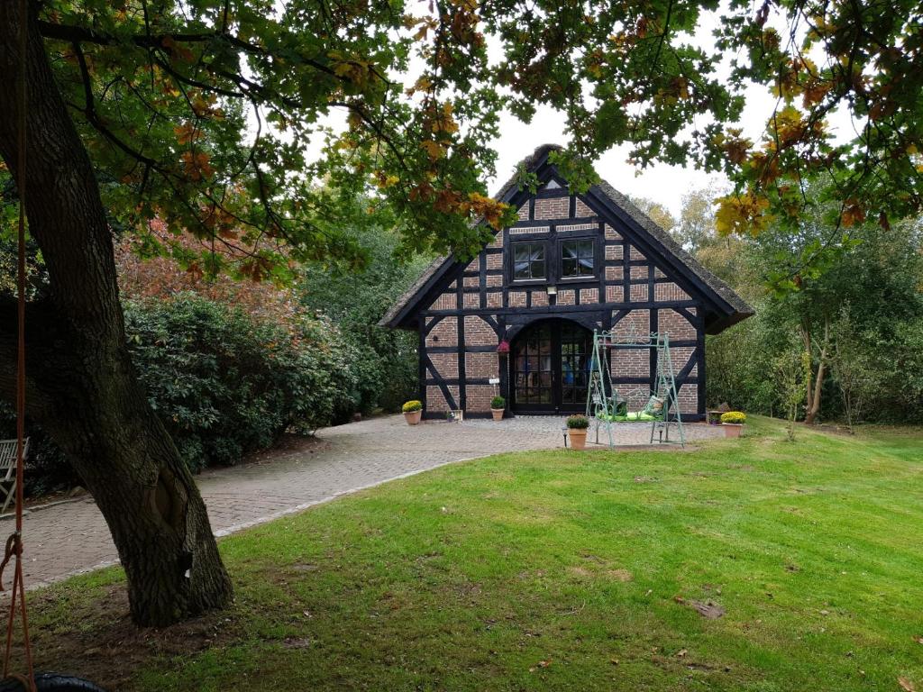 um edifício preto e branco num parque em Ferienhaus Oak-Tree-Cottage em Beverstedt