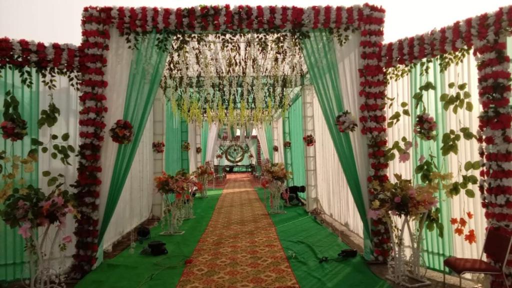 an aisle of a room with green and red decorations at Hotel Royal Grand in Dehradun