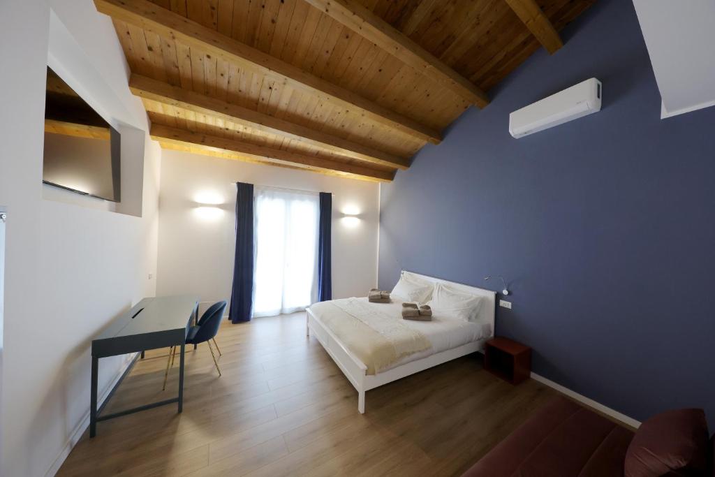 a bedroom with a bed and a desk and a blue wall at Argenteria5 Holiday Rooms in Palermo