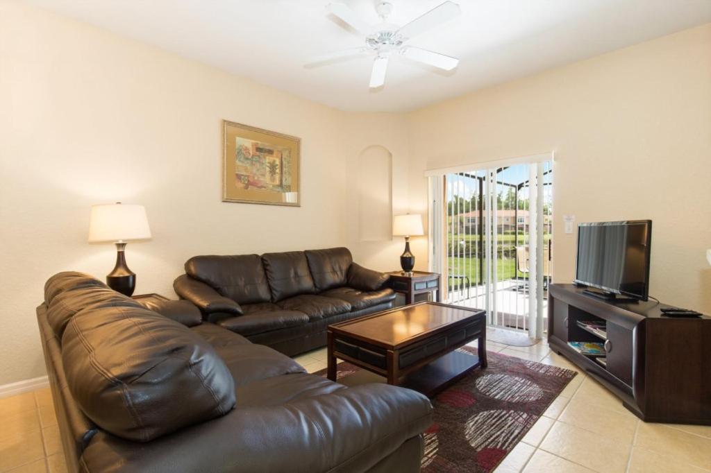 a living room with a leather couch and a television at Kosies Lake Escape in Orlando
