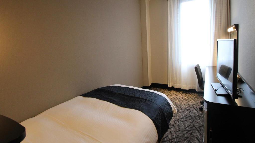 Postel nebo postele na pokoji v ubytování APA Hotel Fukuoka Yukuhashi Ekimae