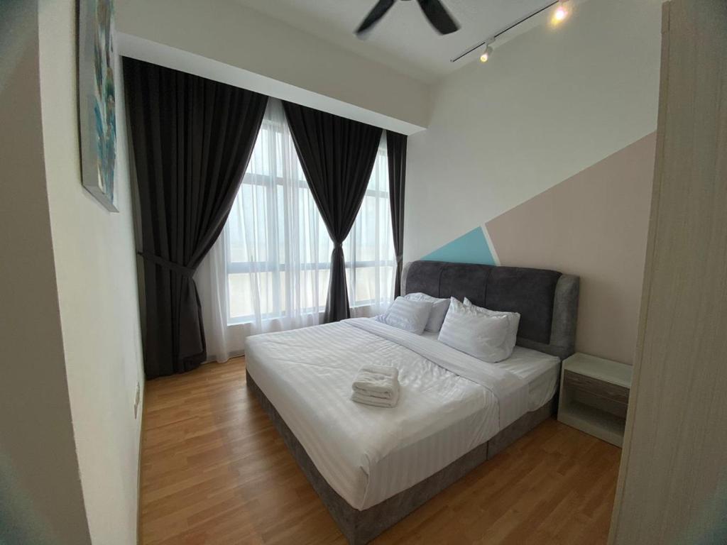 1 dormitorio con 1 cama con sábanas blancas y ventanas grandes en Imperium Residence Kuantan 2 Bedroom Sea View, en Kuantan