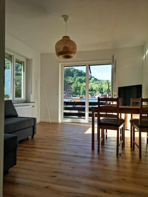 sala de estar con sofá, mesa y sillas en Ferienwohnung Villa Portugal, en Leinsweiler