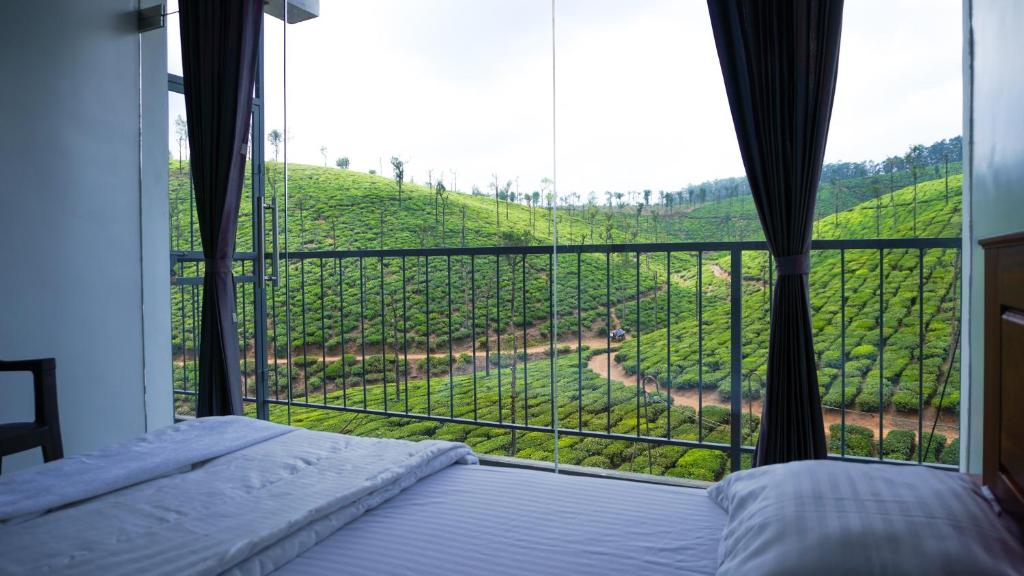 - une chambre avec un lit et une vue sur un vignoble dans l'établissement Zen Vista, à Valparai