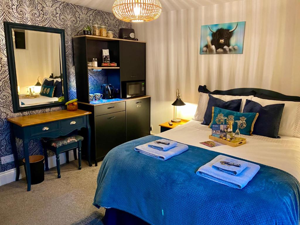 Schlafzimmer mit einem Bett, einem Schreibtisch und einem Spiegel in der Unterkunft The Sapling in Delabole