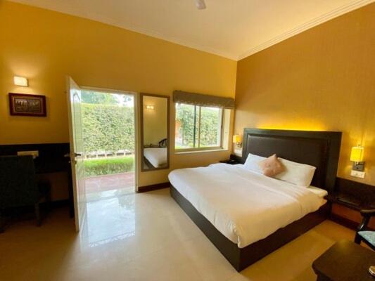 a bedroom with a large bed and a window at Status Club Resort in Kānpur