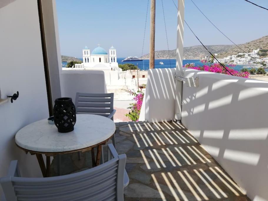 un tavolo e sedie su un balcone con vista sull'oceano di Orantes Maris Luxury a Katápola