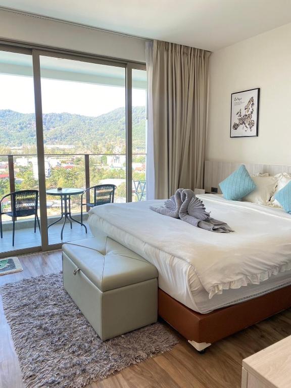a bedroom with a large bed and a balcony at OCEANA HOME Phuket Kamala in Kamala Beach