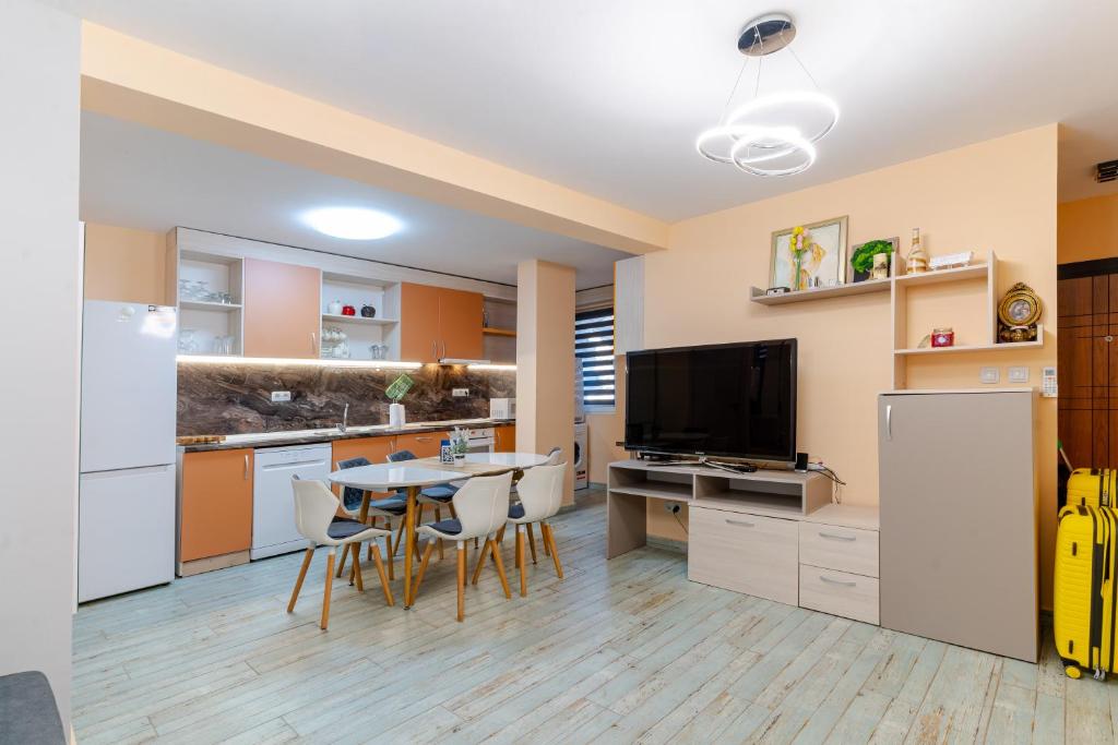 a kitchen and dining room with a table and a tv at Mirela Guest Apartment in Veliko Tŭrnovo