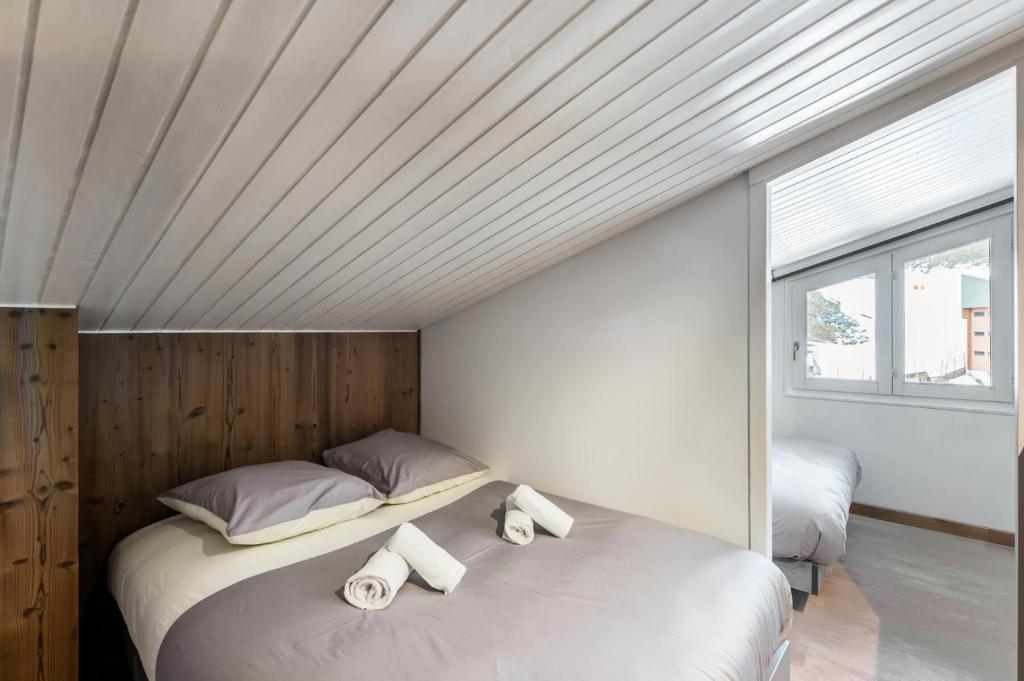 1 dormitorio con 1 cama y 2 toallas enrolladas en Résidence La Roche Blanche - 3 Pièces pour 6 Personnes 264, en Val Thorens