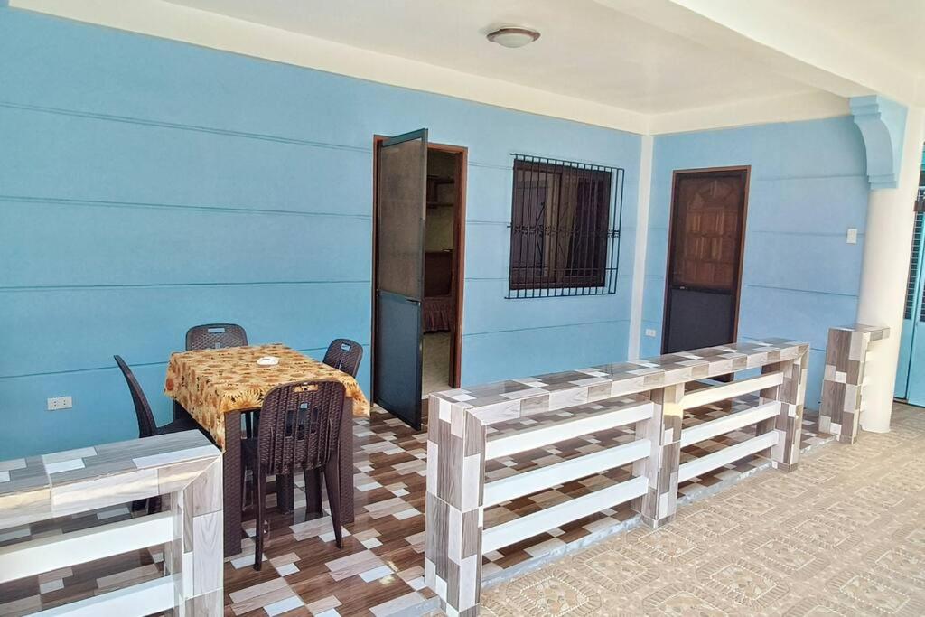 a blue room with a table and chairs at Lemon House in Puerto Galera