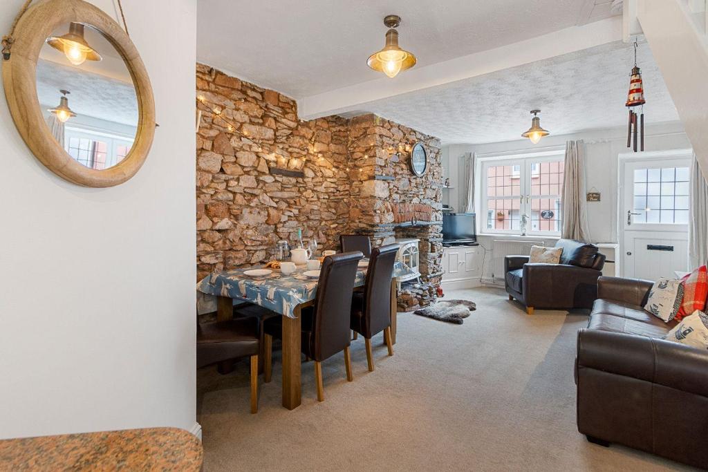 a dining room and living room with a stone wall at Sam Bs in Brixham