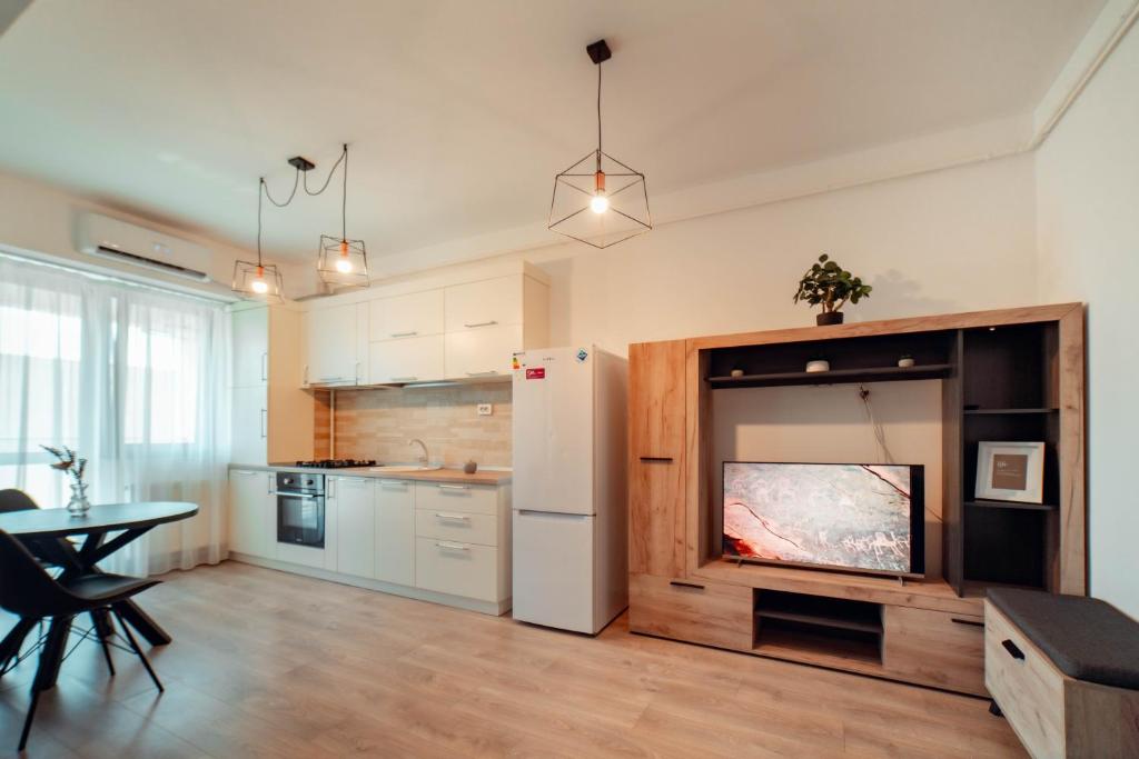 a kitchen with a large white refrigerator and a table at Exclusive Collection Palas Mall Suites and Studios in Iaşi