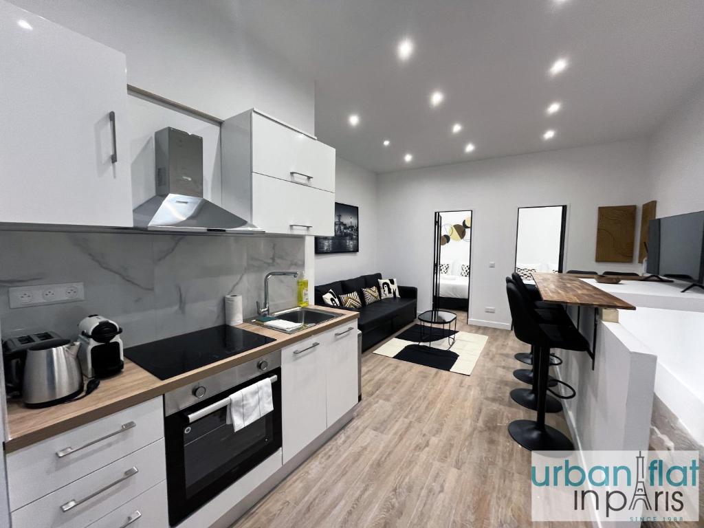 une cuisine avec des armoires blanches et un comptoir dans l'établissement Urban Flat 01 - Charming 2 bedroom Flat in Montorgueil, à Paris