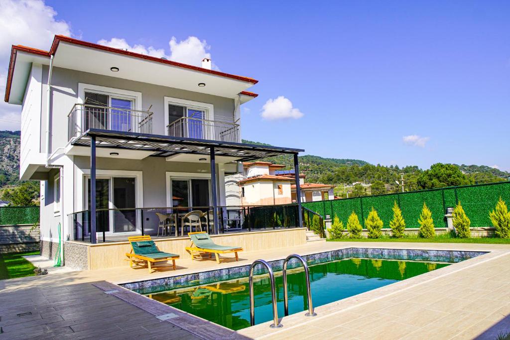a villa with a swimming pool and a house at golden sand sarıgerme in Dalaman