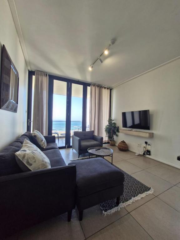 a living room with a couch and a tv at Accommodation Front - Ocean View 2 Sleeper in Durban