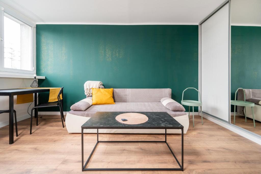 a living room with a couch and a table at Atlas Arena Green Studio in Łódź