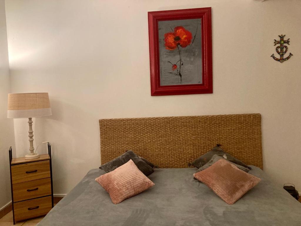 a bedroom with a bed with a red picture on the wall at Mas de la pie in Saintes-Maries-de-la-Mer