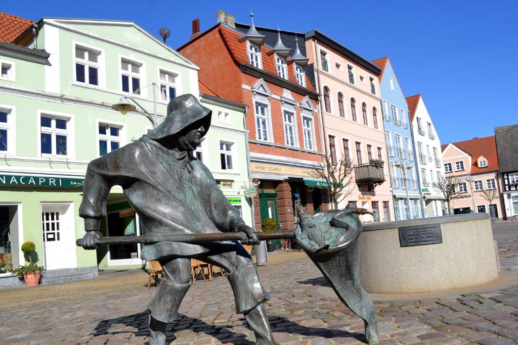 a statue of a woman holding a cat in a street at Ferienwohnung ab zum Haff in Ueckermünde