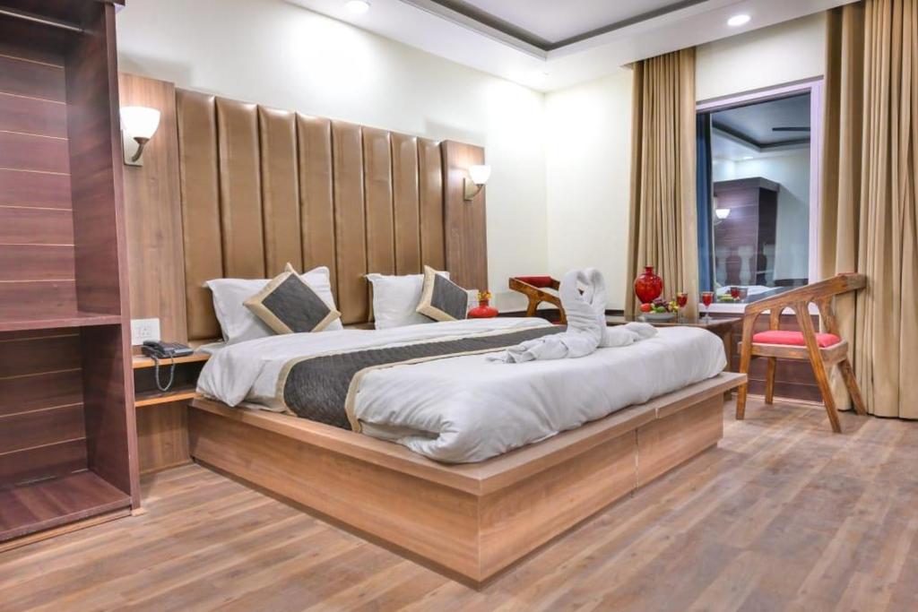 - une chambre avec un grand lit et une tête de lit en bois dans l'établissement Royal Park by Zaraza, à Srinagar