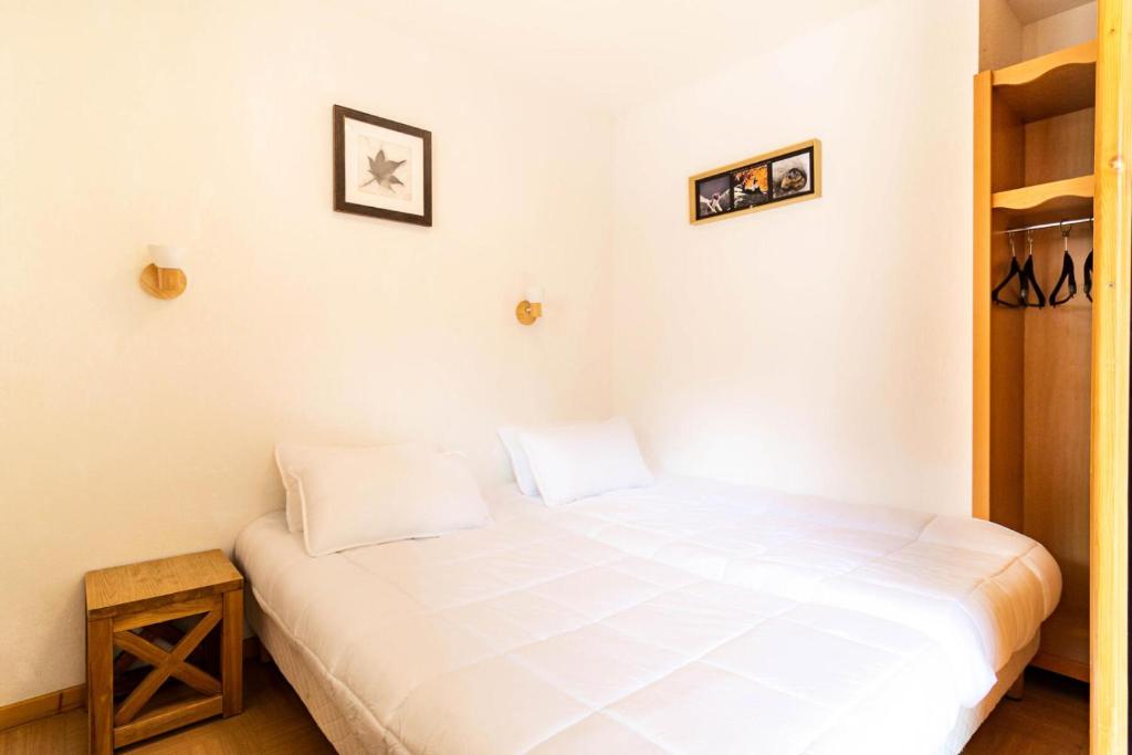 a bedroom with a white bed in a room at Résidence Le Parc Des Airelles - 2 Pièces pour 4 Personnes 454 in Les Orres