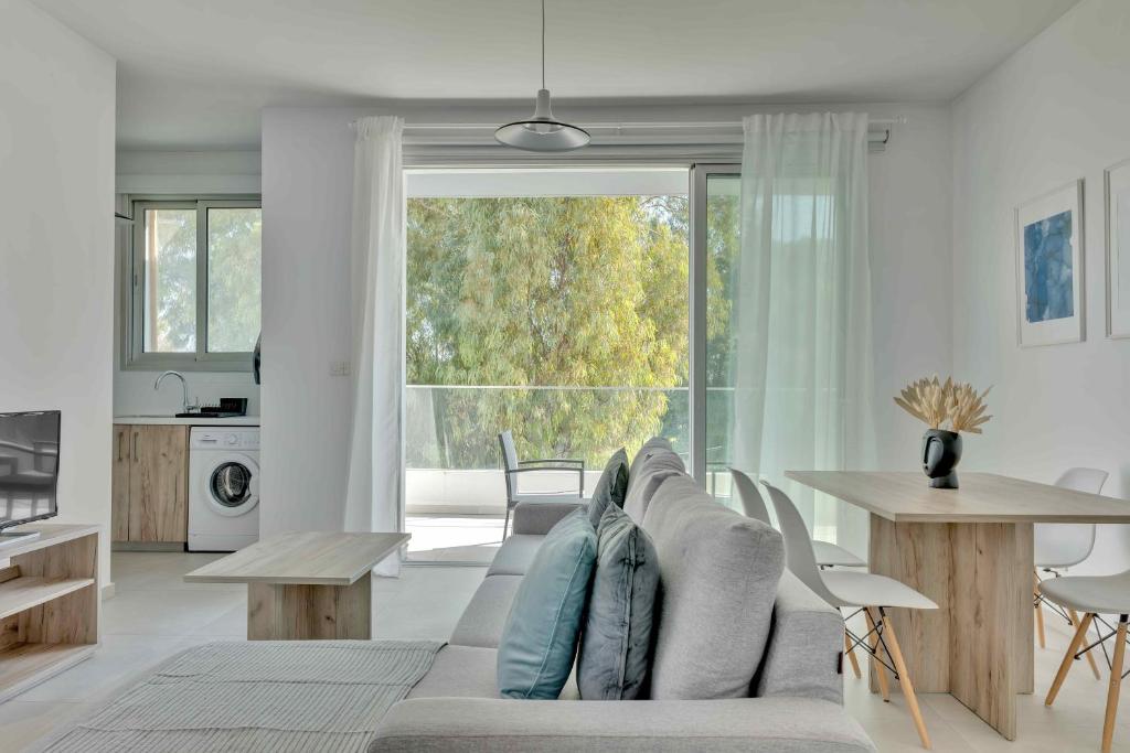 - un salon avec un canapé et une grande fenêtre dans l'établissement Phaedrus Living: City Center Residences Emerald, à Nicosie