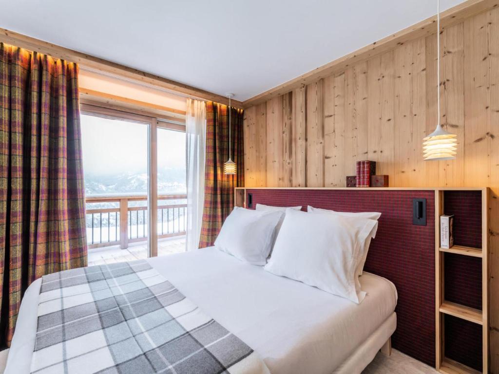 a bedroom with a large bed and a window at Résidence Beloukha - Chalets pour 12 Personnes 734 in Saint-Bon-Tarentaise