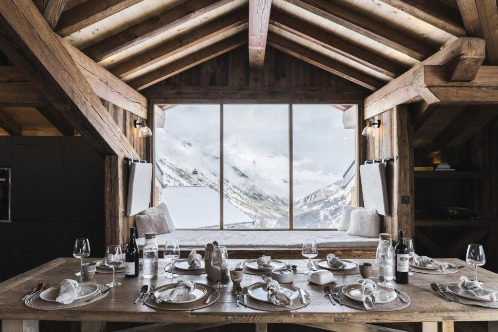 a dining table with a view of a snow covered mountain at Résidence Le Bercail - Chalets pour 12 Personnes 224 in Saint-Martin-de-Belleville