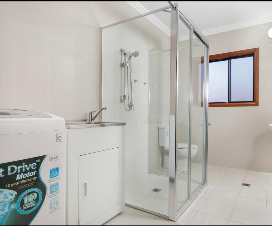 a bathroom with a shower with a sink and a toilet at 68 Frederick in Sydney