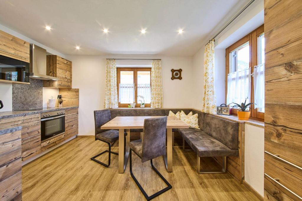 eine Küche mit einem Holztisch und Stühlen in der Unterkunft Miller Appartements in Sankt Veit im Pongau