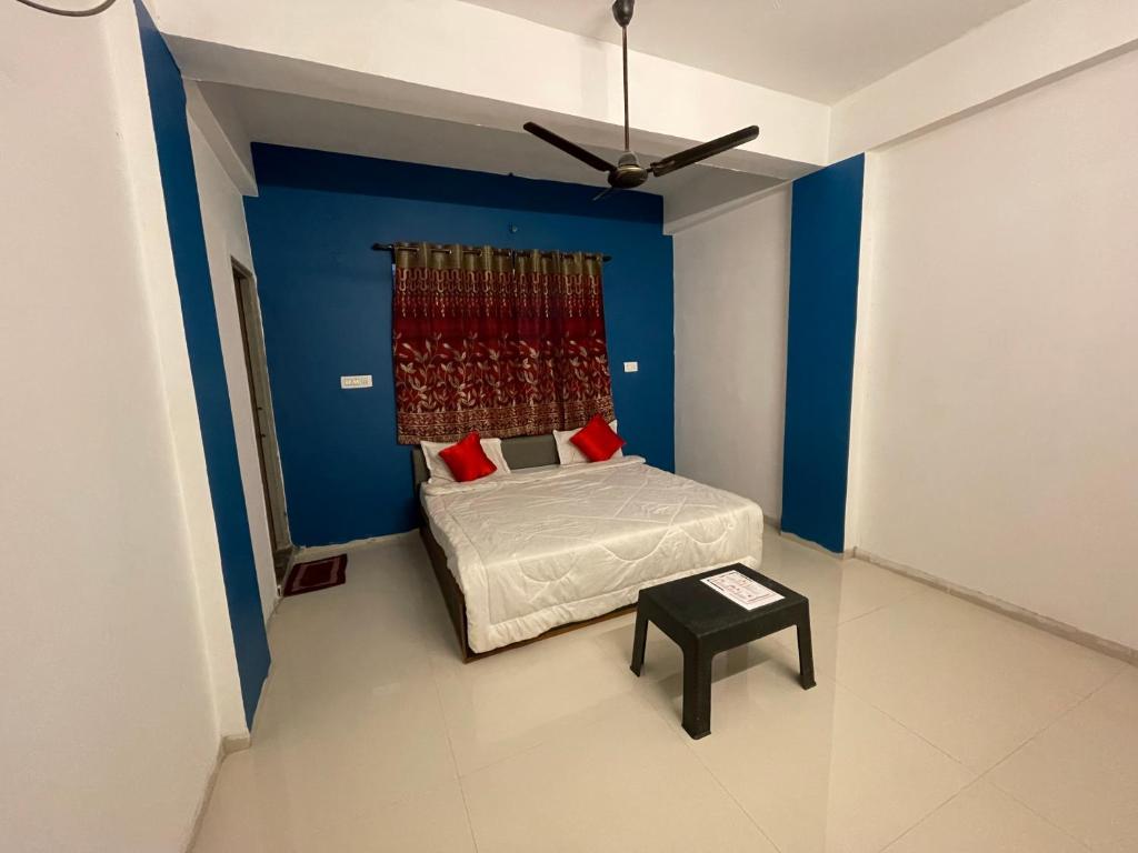 ein Schlafzimmer mit einem Bett und einer blauen Wand in der Unterkunft Hotel Kings Inn in Nagpur
