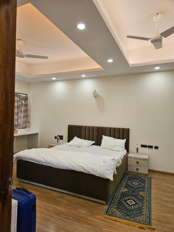 a bedroom with a bed and a blue suitcase at Villa in Vrindavan, Hare Krishna M (ISKCON) campus in Vrindāvan