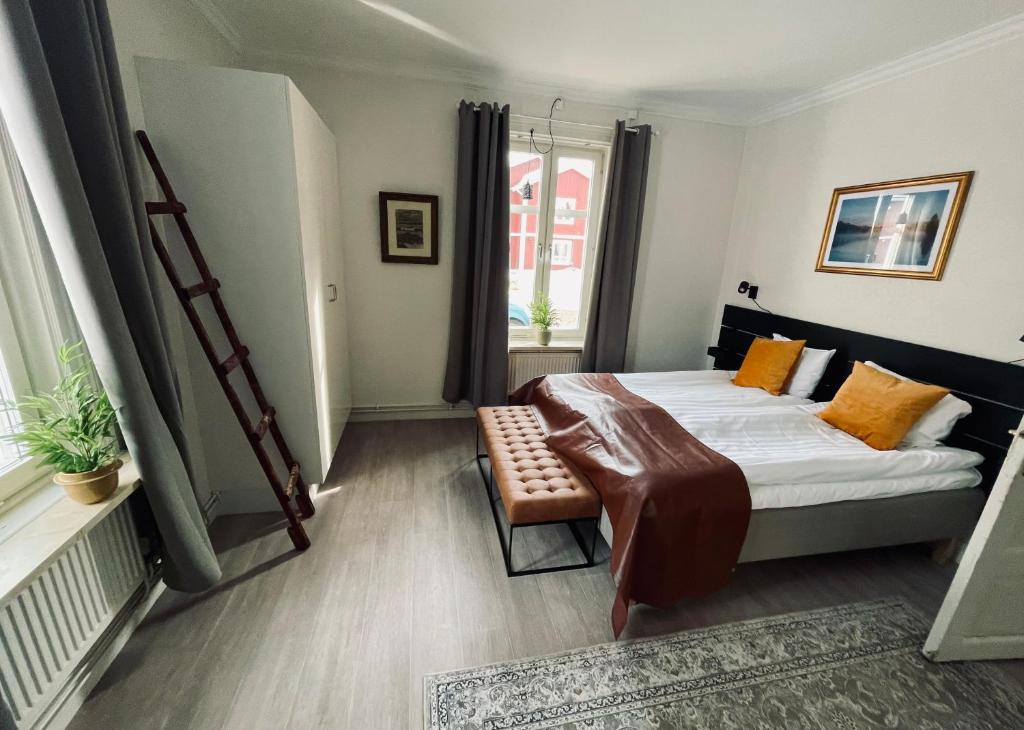 Telegrafen Lägenhetshotell في سفيغ: غرفة نوم بسرير وكرسي ونافذة