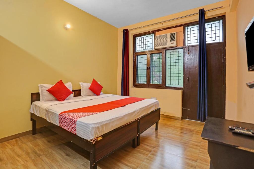 ein Schlafzimmer mit einem Bett mit roten Kissen darauf in der Unterkunft OYO Prince Residency in Greater Noida