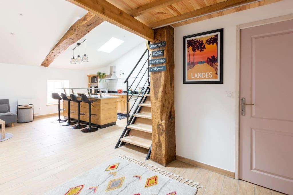 Il comprend un salon décloisonné avec un escalier et une cuisine. dans l'établissement Le nid de bois - Centre ville -Thermes-Center Parc, à Casteljaloux