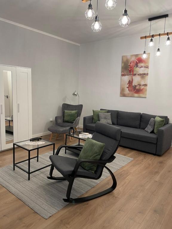 a living room with a couch and a table and chairs at Zwinger Apartman in Sopron