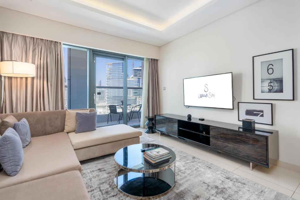 een woonkamer met een bank en een tafel bij Ultimate Stay / Luxurious Living at its Finest in Dubai