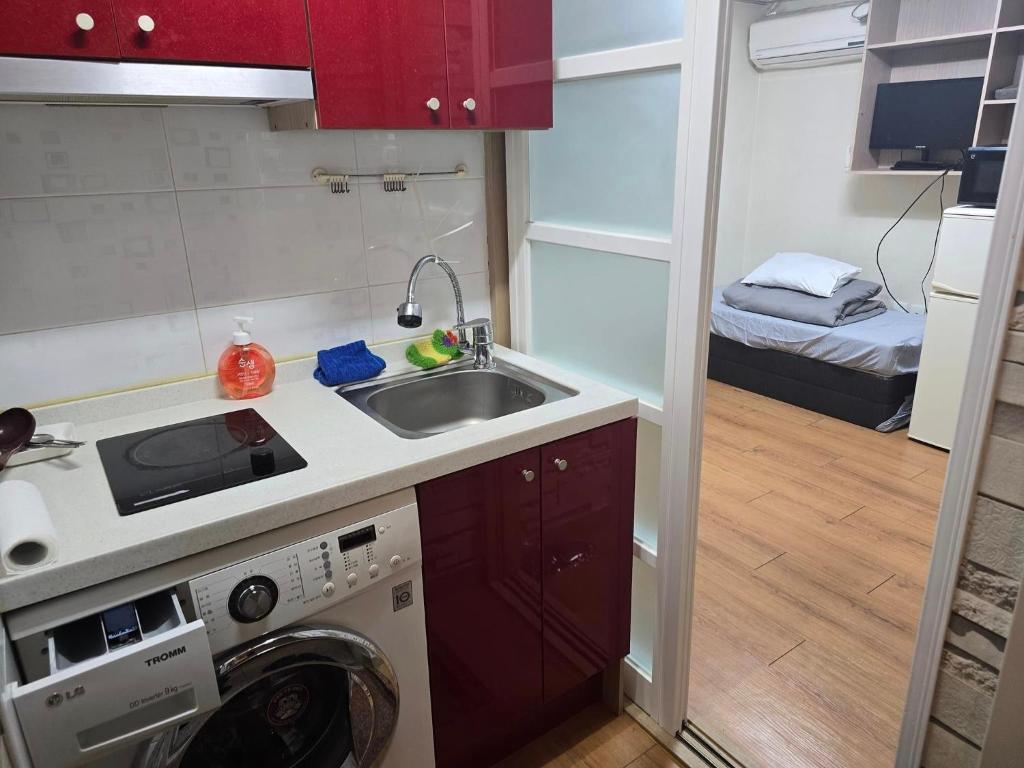 a kitchen with a sink and a washing machine at Dongdaemun Studio in Seoul